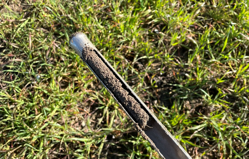 Metal tube pulled out of the ground containing a sample of the soil for testing.