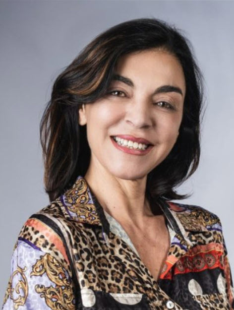 Dr. Stefania De Pascale, with shoulder-length dark hair, smiles at the camera, wearing a patterned shirt with leopard and abstract designs at the CAES Guest Seminar.